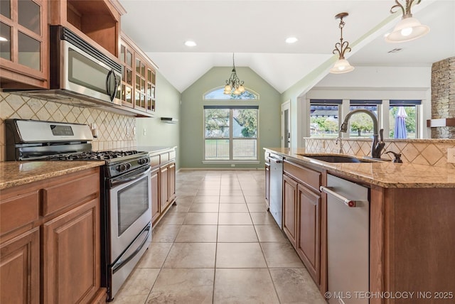 kitchen with stainless steel appliances, sink, decorative light fixtures, a chandelier, and lofted ceiling