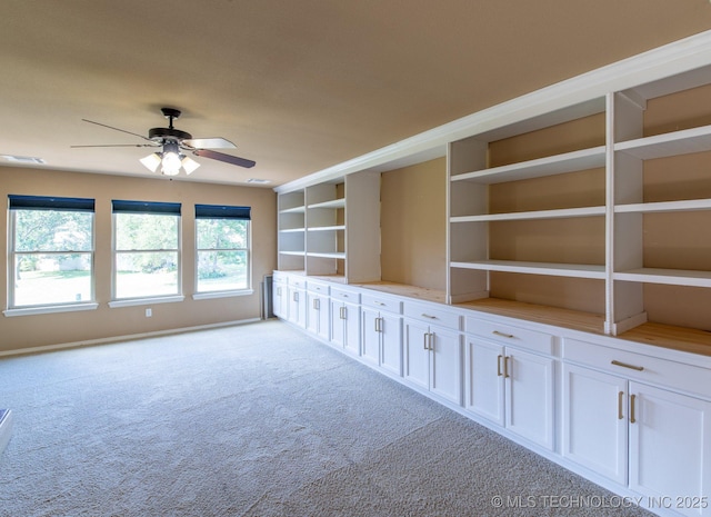 interior space with ceiling fan and light colored carpet