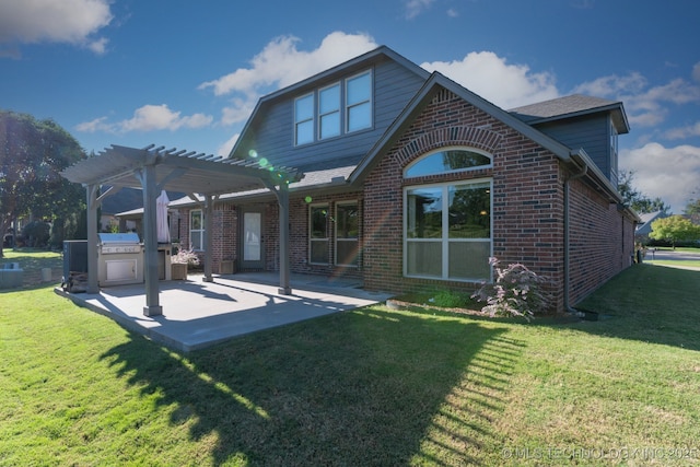 back of property with a pergola, a lawn, brick siding, and a patio