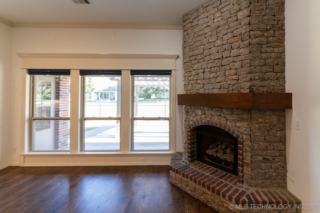 unfurnished living room featuring a fireplace, ornamental molding, and dark hardwood / wood-style floors