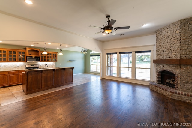 kitchen featuring backsplash, decorative light fixtures, a wealth of natural light, and appliances with stainless steel finishes