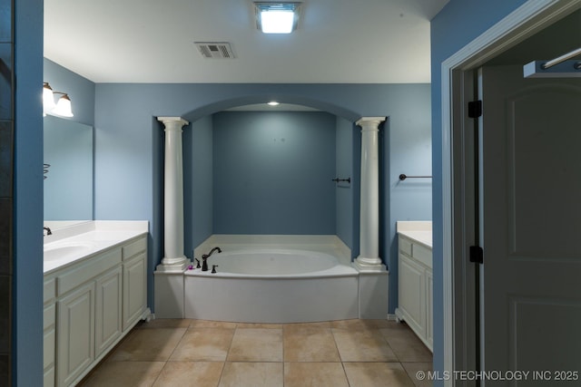 bathroom with decorative columns, vanity, a tub, and tile patterned flooring