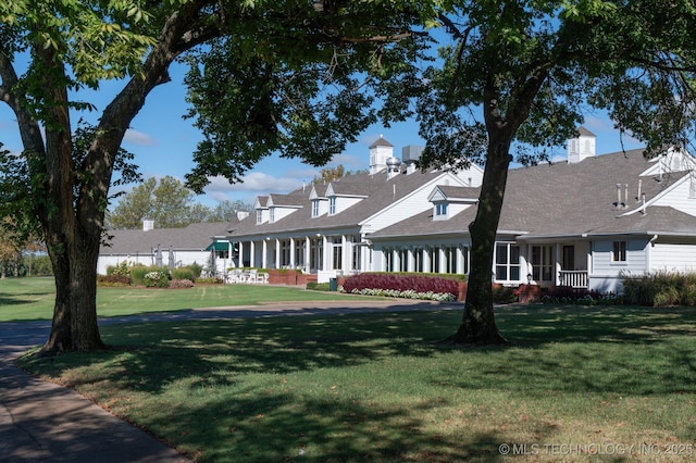 cape cod home with a front lawn
