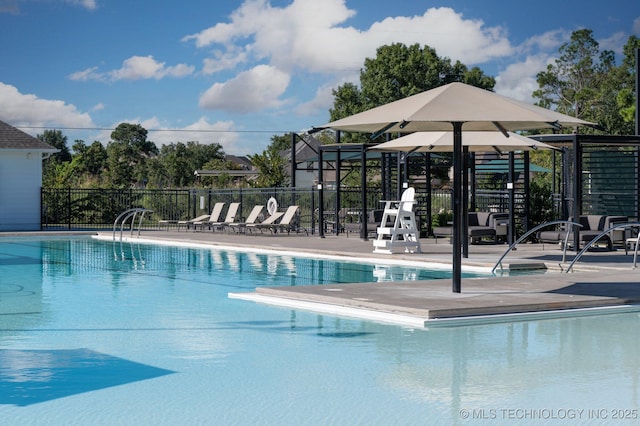 pool with a patio area and fence