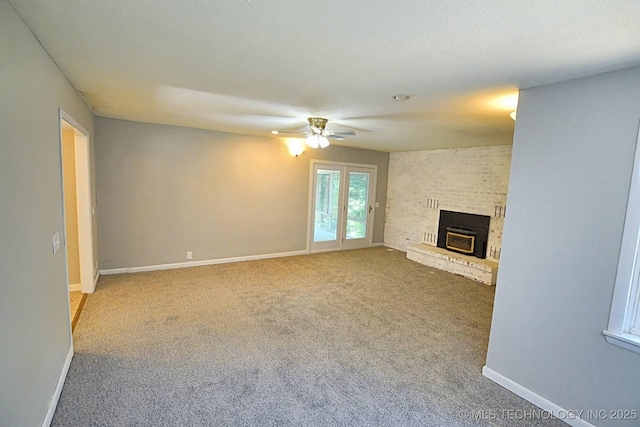 unfurnished living room featuring ceiling fan, carpet, and a brick fireplace