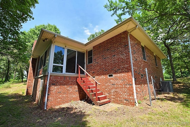 view of front of home featuring central AC and a sunroom