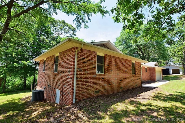 view of side of home featuring a lawn, an outbuilding, cooling unit, and a garage