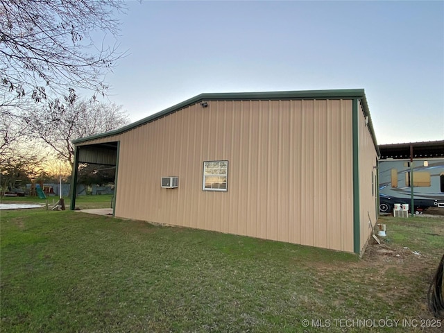 property exterior at dusk with a lawn and a wall mounted air conditioner