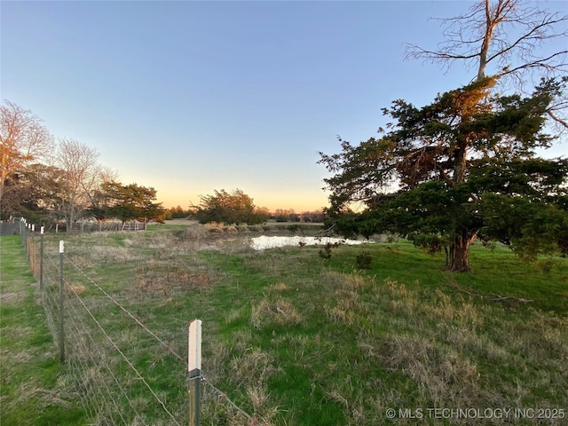 yard at dusk with a rural view