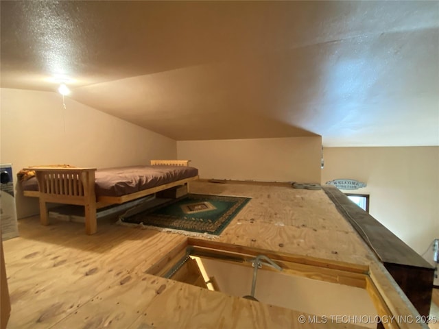 bedroom with a textured ceiling and lofted ceiling