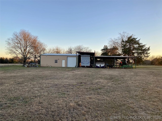 outdoor structure at dusk with a yard and a garage