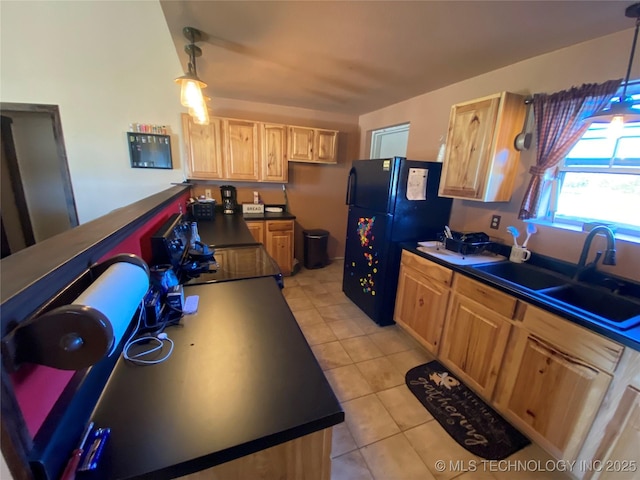 kitchen with black refrigerator, sink, pendant lighting, and light brown cabinets