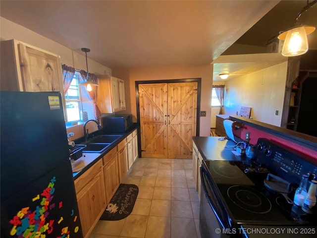 kitchen featuring pendant lighting, a wealth of natural light, sink, and black appliances