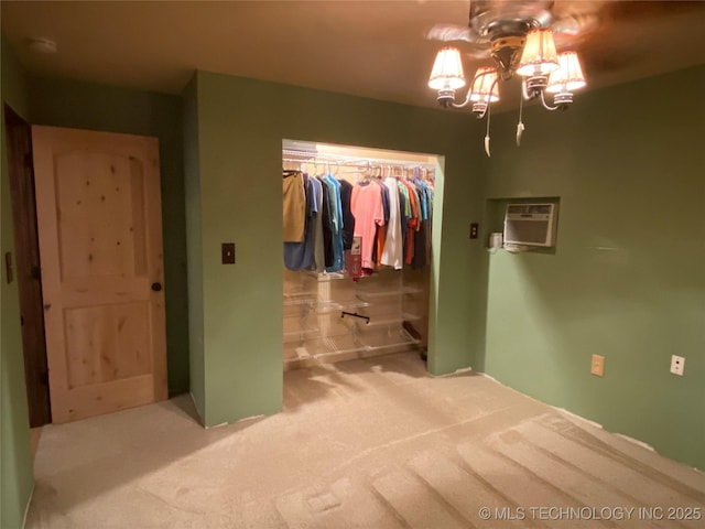 bedroom with an inviting chandelier, carpet floors, a wall unit AC, and a closet