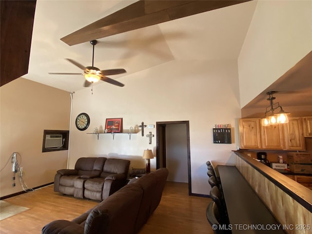 living room with a wall unit AC, ceiling fan, lofted ceiling with beams, and light wood-type flooring