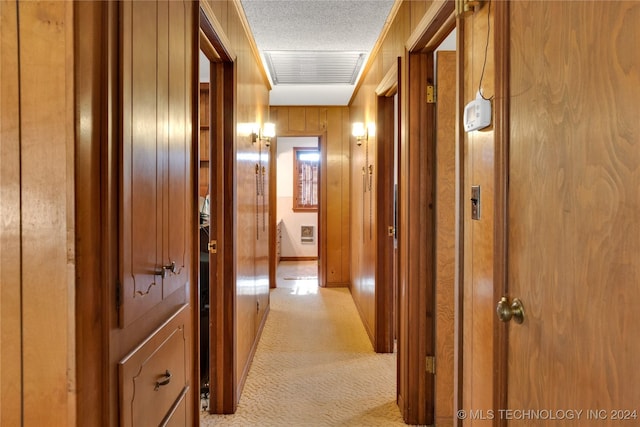 hall featuring ornamental molding, a textured ceiling, and wooden walls