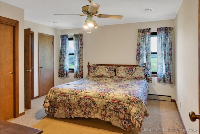 carpeted bedroom featuring multiple windows, a textured ceiling, ceiling fan, and a baseboard heating unit