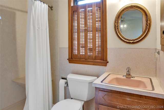 bathroom featuring walk in shower, vanity, and toilet