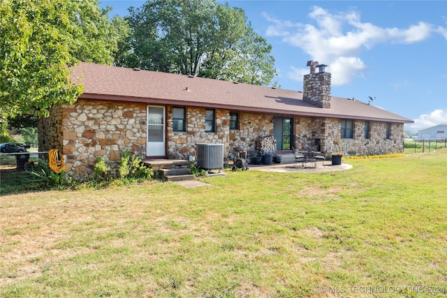 rear view of house with a patio area, a yard, and central AC