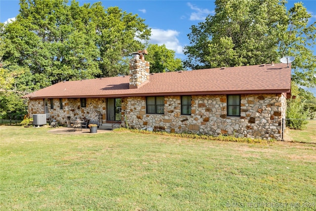 rear view of house featuring a lawn, central AC, and a patio area