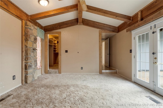 empty room with light carpet, french doors, and lofted ceiling with beams