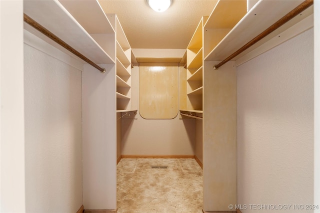 walk in closet featuring light colored carpet