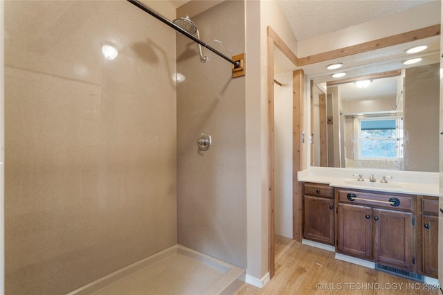 bathroom featuring hardwood / wood-style floors, vanity, and a textured ceiling