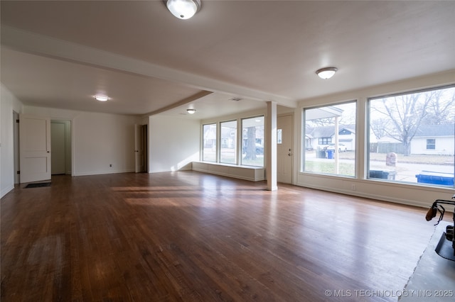 unfurnished living room featuring a wealth of natural light and hardwood / wood-style floors