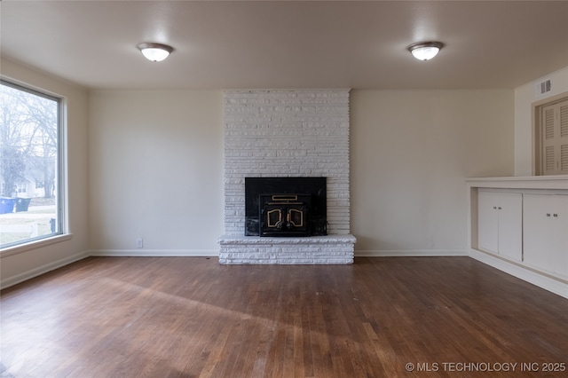 unfurnished living room with plenty of natural light and dark wood-type flooring