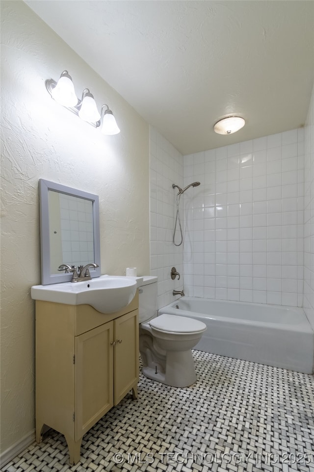 full bathroom featuring vanity, tiled shower / bath combo, and toilet