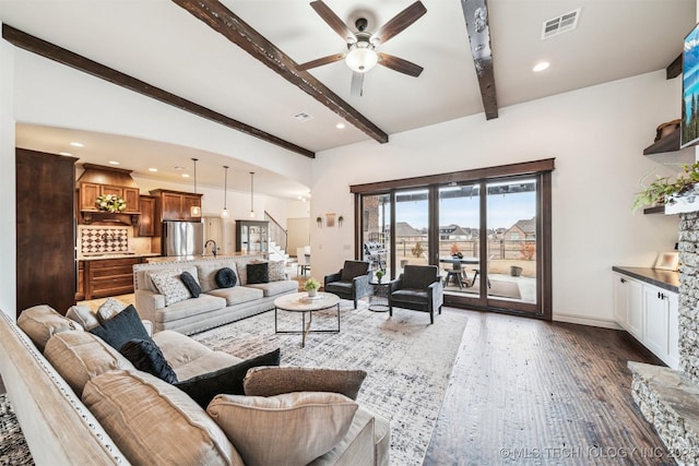 living room featuring beamed ceiling, dark hardwood / wood-style flooring, ceiling fan, and sink