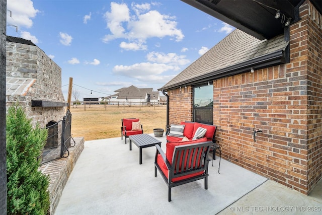 view of patio with an outdoor living space with a fireplace