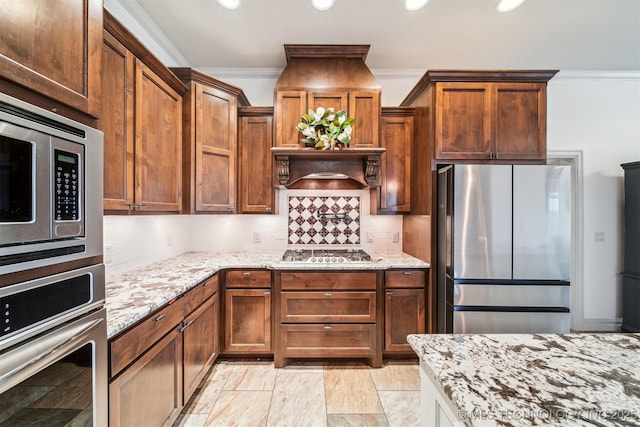 kitchen featuring premium range hood, light stone counters, tasteful backsplash, ornamental molding, and stainless steel appliances