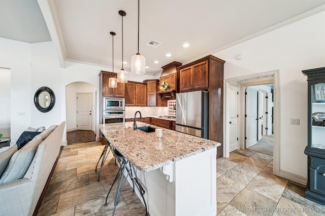 kitchen with pendant lighting, sink, crown molding, a kitchen bar, and stainless steel appliances