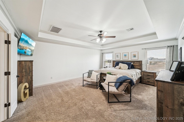 bedroom with ceiling fan, carpet floors, crown molding, and a tray ceiling