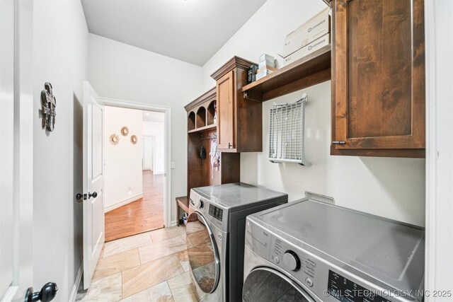 washroom with washer and clothes dryer and cabinets