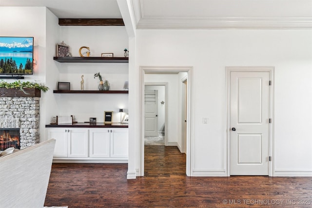 bar featuring beamed ceiling, a fireplace, white cabinets, and dark wood-type flooring