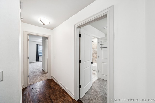 hall featuring dark colored carpet