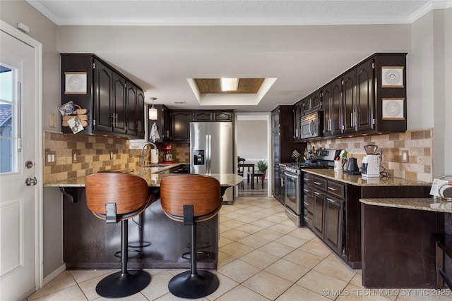 kitchen with light tile patterned floors, stainless steel appliances, tasteful backsplash, and a breakfast bar area