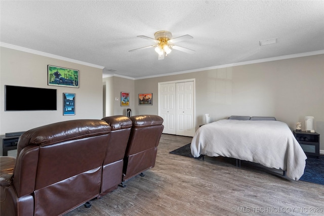 bedroom featuring a textured ceiling, a closet, ceiling fan, and ornamental molding