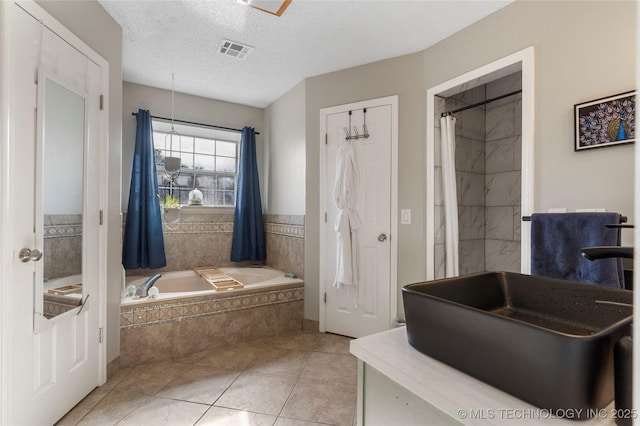 bathroom featuring tile patterned flooring, shower with separate bathtub, a textured ceiling, and sink