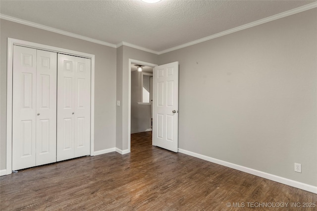 unfurnished bedroom with dark wood-type flooring, ornamental molding, a closet, and a textured ceiling