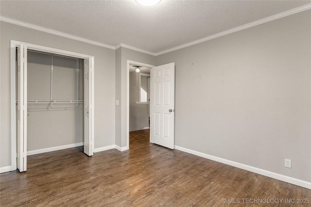 unfurnished bedroom featuring a closet, crown molding, dark hardwood / wood-style floors, and a textured ceiling