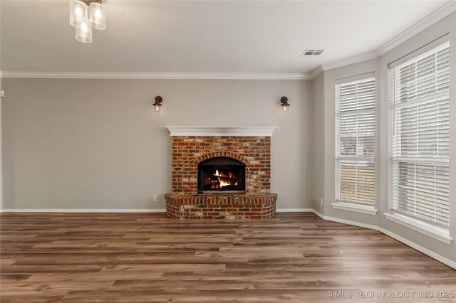 unfurnished living room with a brick fireplace, crown molding, and hardwood / wood-style floors