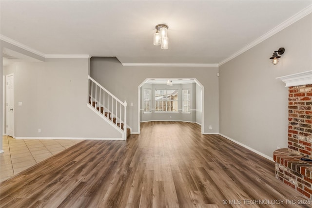 unfurnished living room with hardwood / wood-style flooring and crown molding