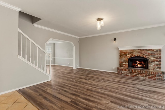 unfurnished living room featuring crown molding, wood-type flooring, and a fireplace