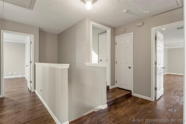 corridor featuring dark hardwood / wood-style flooring and a textured ceiling