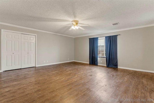 empty room featuring crown molding, ceiling fan, wood-type flooring, and a textured ceiling