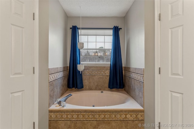 bathroom featuring tiled bath and a textured ceiling