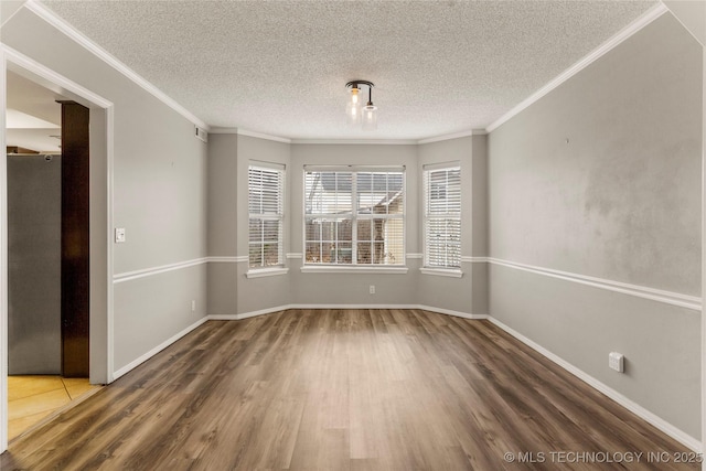 spare room featuring ornamental molding, wood-type flooring, and a textured ceiling